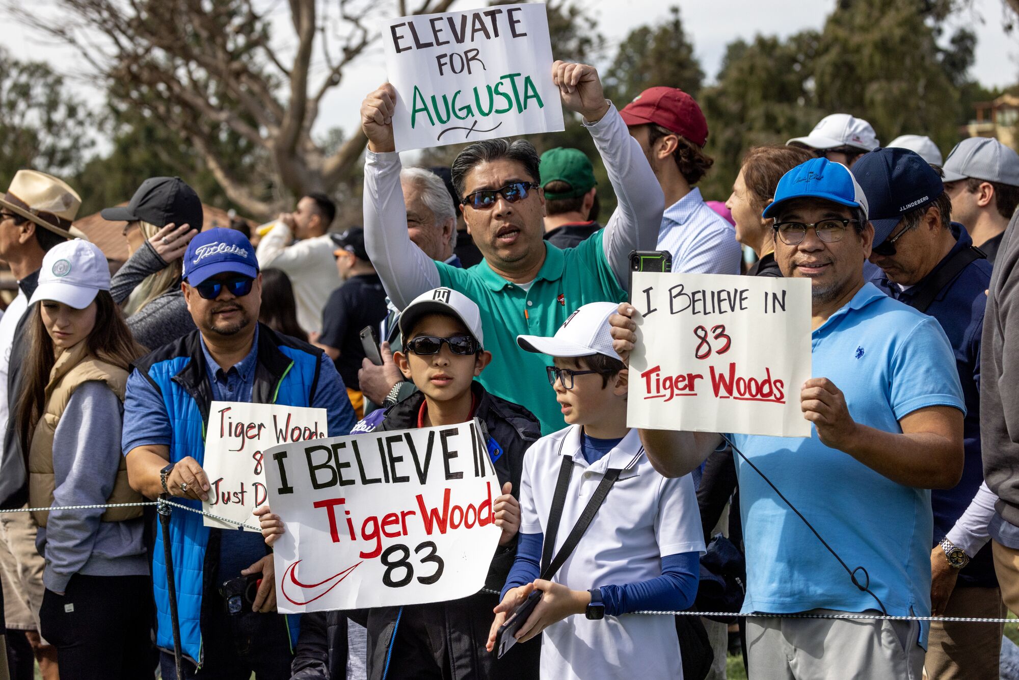 Fans hold signs in support of Tiger Woods