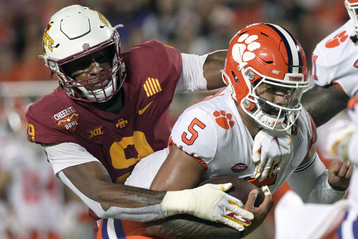 Clemson quarterback D.J. Uiagalelei is tackled by Iowa State defensive end Will McDonald IV after scrambling for yardage.