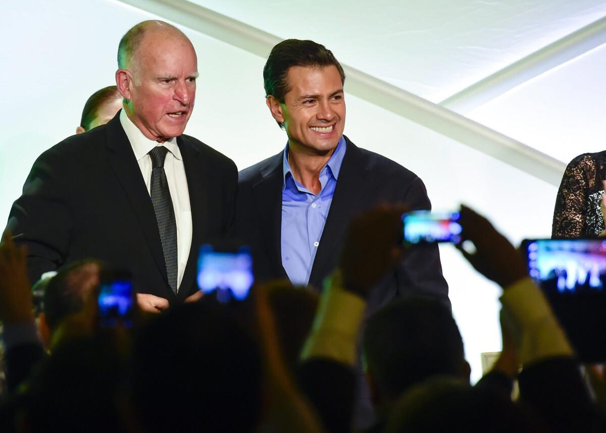 Mexican President Enrique Pena Nieto and Gov. Jerry Brown pose for photos after meeting with local business leaders in Los Angeles in August 2014.
