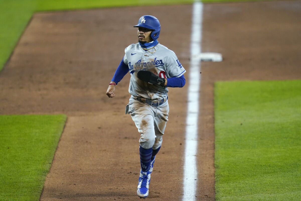 Dodgers' Mookie Betts scores against the Seattle Mariners.