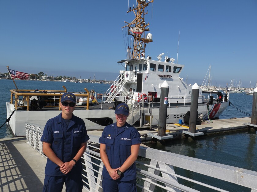 Lt. j.g. Caroline Miller, right, commanding officer of the Coast Guard cutter Narwhal, and Seaman Thomas Roberts are pictured with the 87-foot vessel at its Corona del Mar berth.