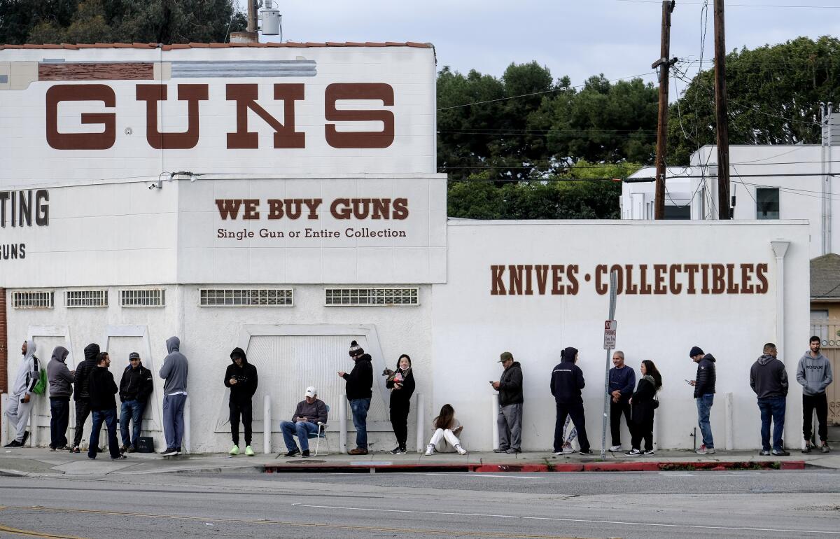 People wait in line outside a gun store.