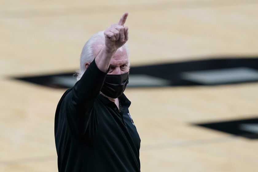 San Antonio Spurs coach Gregg Popovich signals to players during the first half of an NBA basketball game against the Denver Nuggets in San Antonio, Friday, Jan. 29, 2021. (AP Photo/Eric Gay)