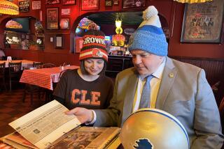 Toledo mayor Wade Kapszukliewicz and wife Sarah look at a scrapbook in a city establishment.