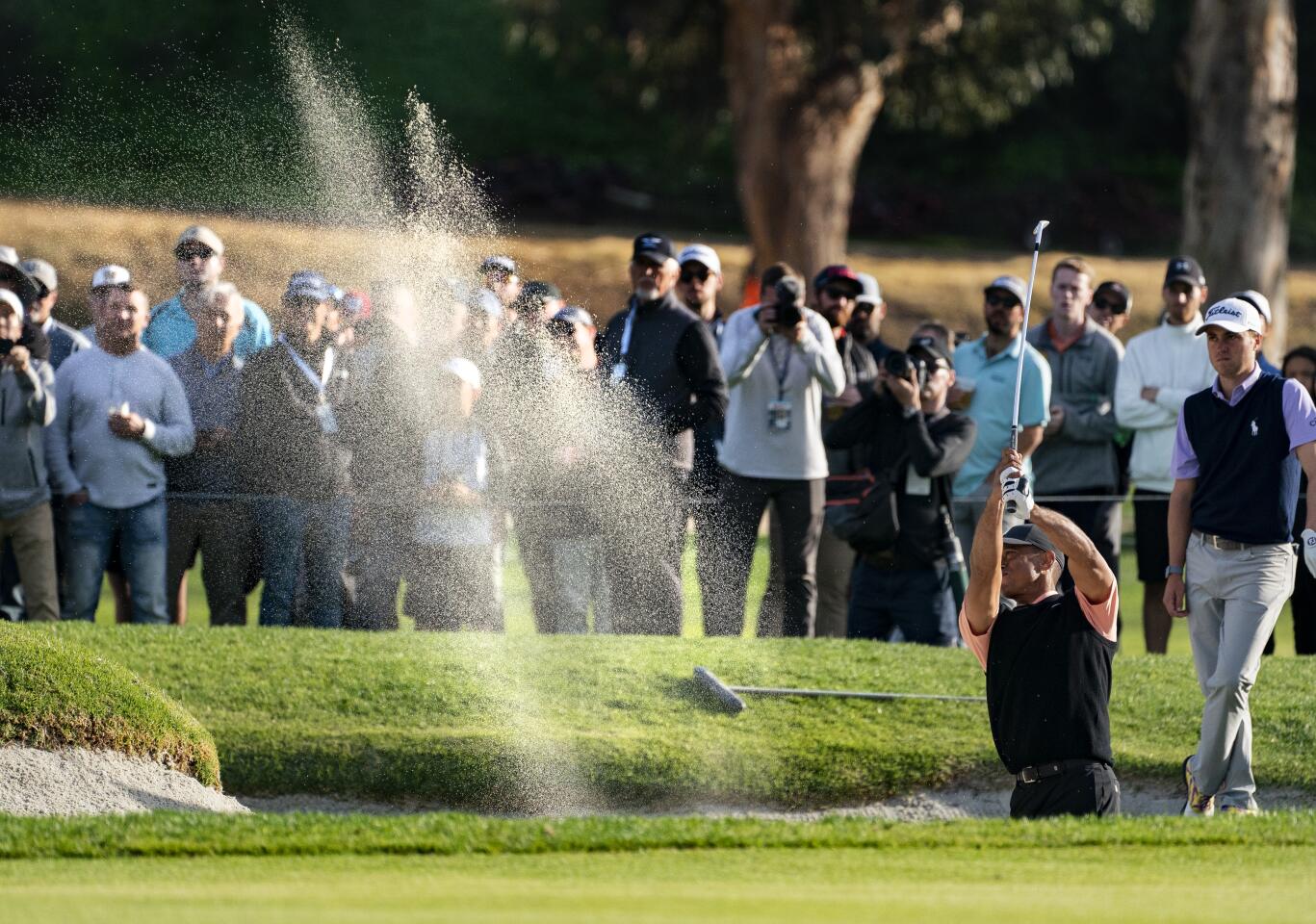 Tiger Woods hits out of a fairway bunker on the 17th hole during the first round of the Genesis Invitational at Riviera Country Club on Feb. 13, 2020.