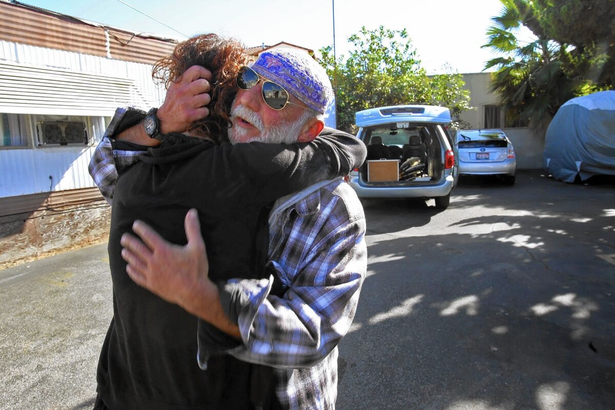 Ischar Zuker hugs neighbor Nikkia Sipes. Developers, who plan to build an upscale apartment complex, have spent more than a year persuading residents to move out.
