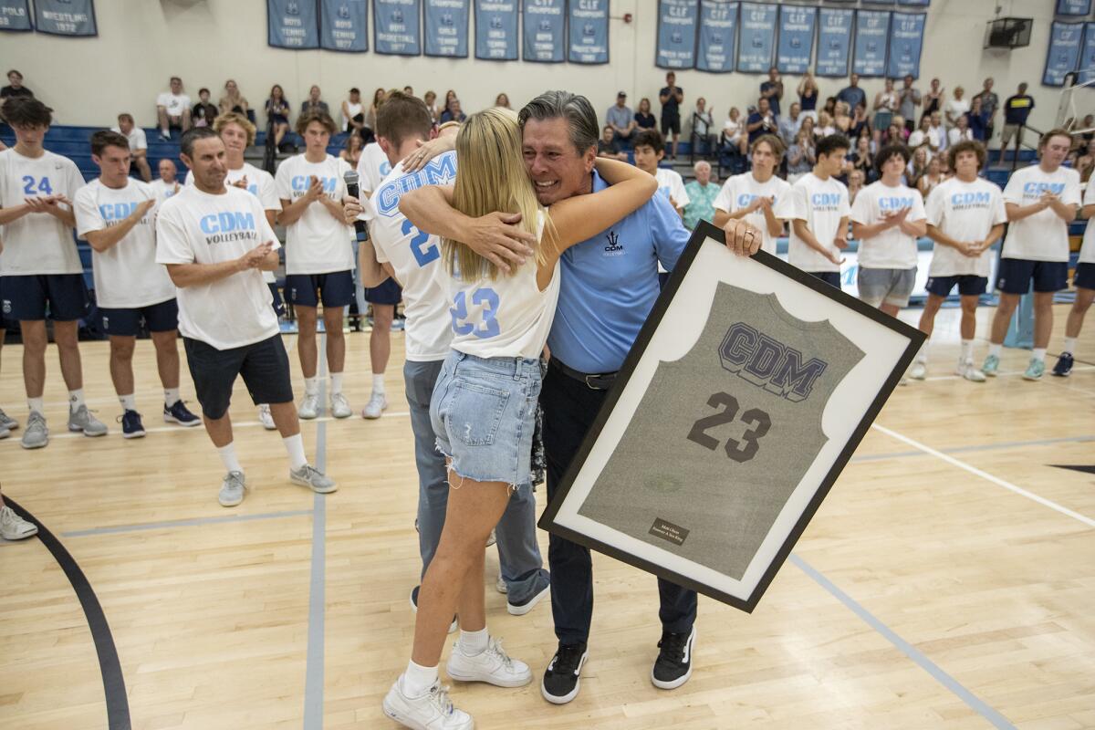 Rex Olson hugs his daughter Taylor after being presented with a CdM jersey that his son Matt wore on Thursday.