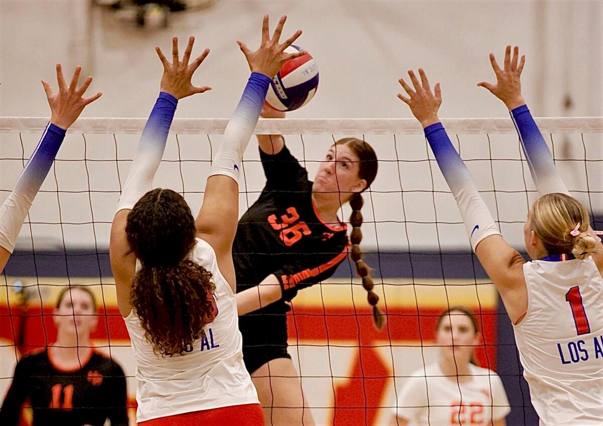 Senior middle blocker Kylie Leopard delivers one of her 11 kills in a five-set win at rival Los Alamitos on Oct. 3.