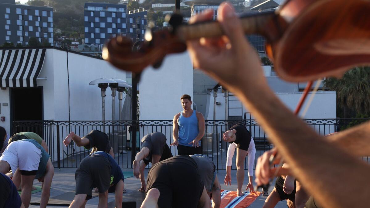 Yoga instructor Jake Ferree and violinist Volkan Can Canbolat team up for Vinyasa & Violin on the roof of Palihouse in West Hollywood.