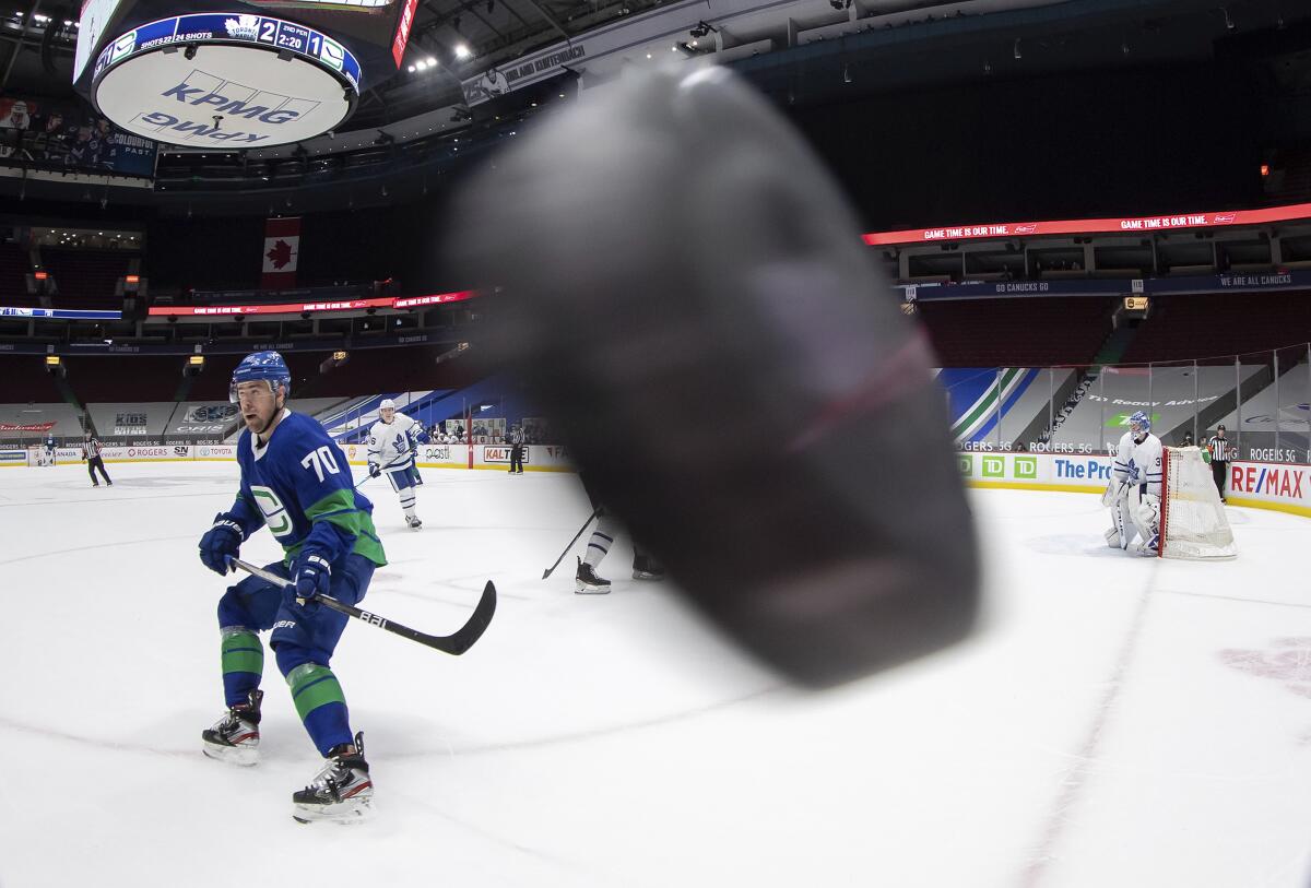 Vancouver Canucks' Tanner Pearson (70) waits for the puck to drop down after it was shot around the glass during the second period of an NHL hockey game against the Toronto Maple Leafs in Vancouver, British Columbia, on Saturday, March 6, 2021. (Darryl Dyck/The Canadian Press via AP)