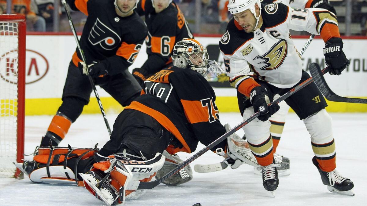 Philadelphia Flyers goalie Carter Hart sticks his leg out to block a scoring attempt by Ducks' Ryan Getzlaf, right, during the first period on Saturday.