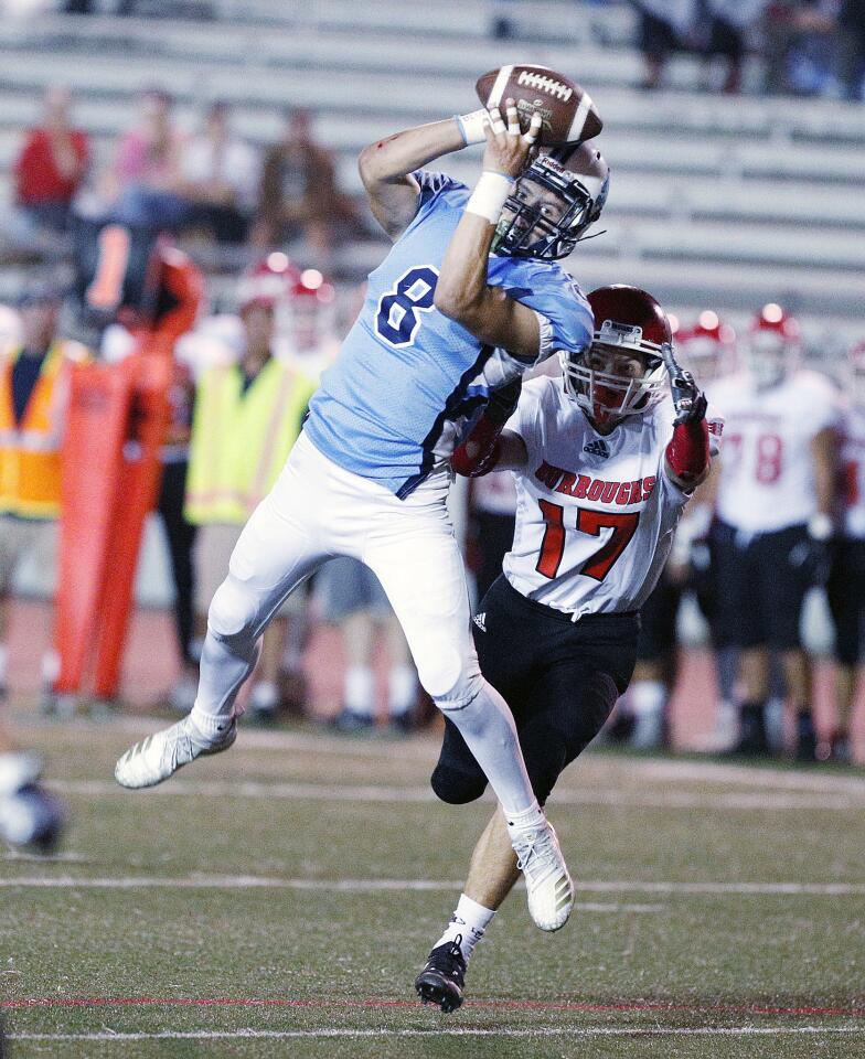 Crescenta Valley's Angel Ochoa makes a catch over Burroughs' Aiden Forrester in the first quarter in a Pacific League football game at Moyse Stadium in Glendale on Thursday, September 27, 2018. Crescenta Valley lead Burroughs 7-0 at halftime.