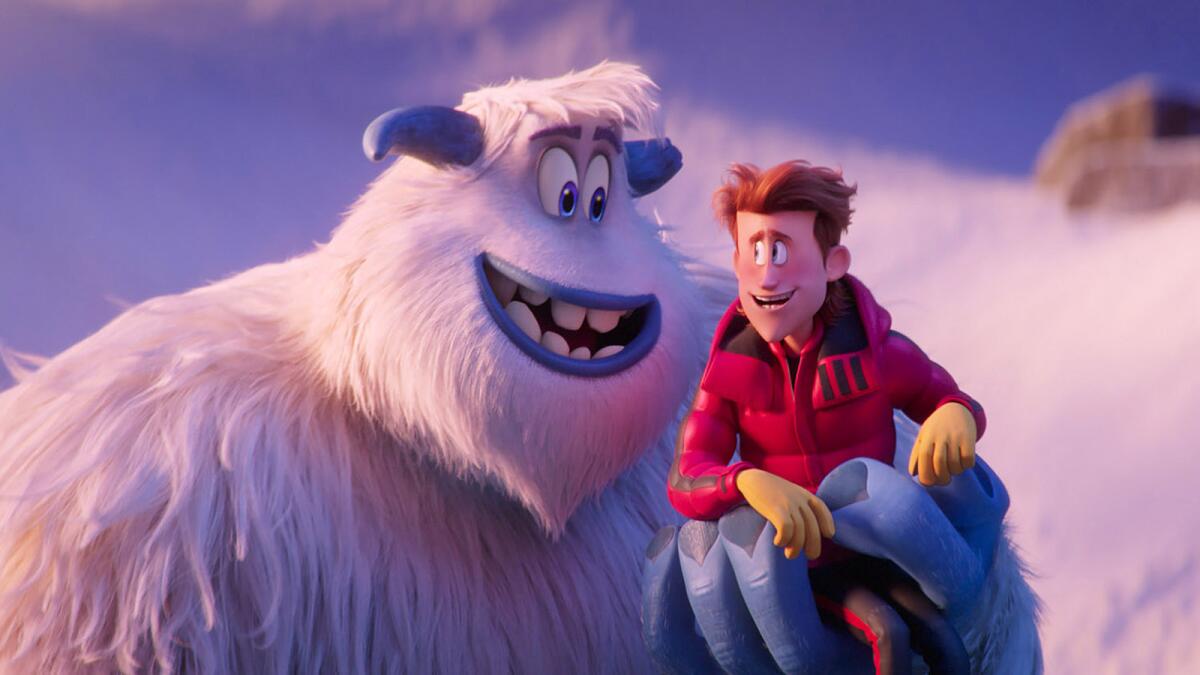 A Yeti holds a man in his hand in the animated film "Smallfoot."