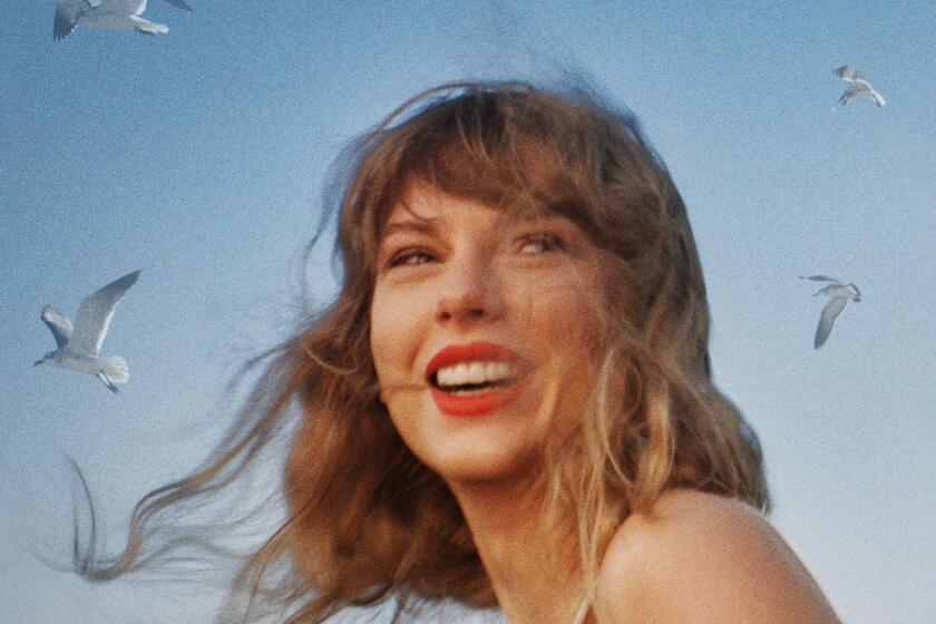 Taylor Swift turns her head and smiles as her hair blows in the wind with seagulls flying overhead