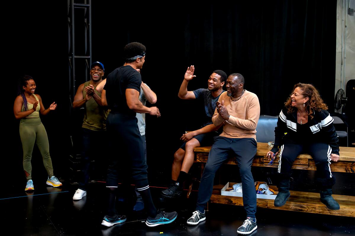 A group of men and women rehearse a play.  