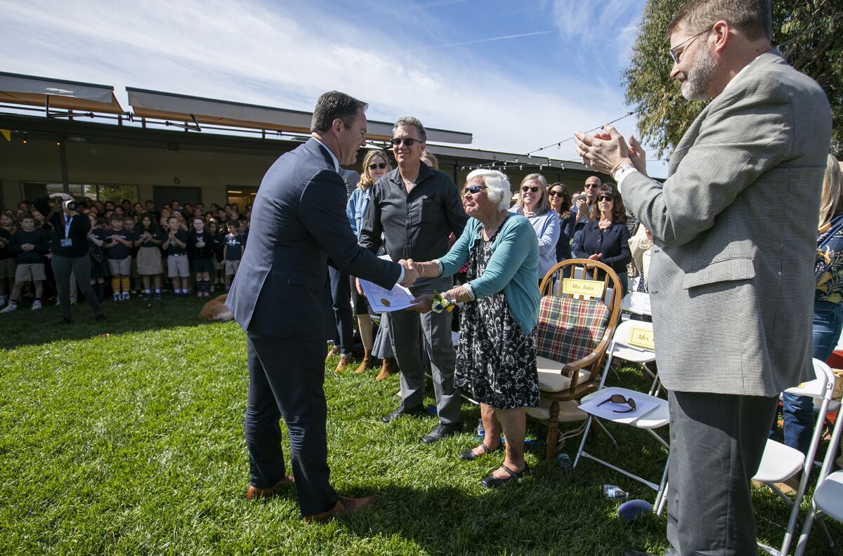 Mayor Pro Tem Will O'Neill, left, shakes hands with Jane Jones.