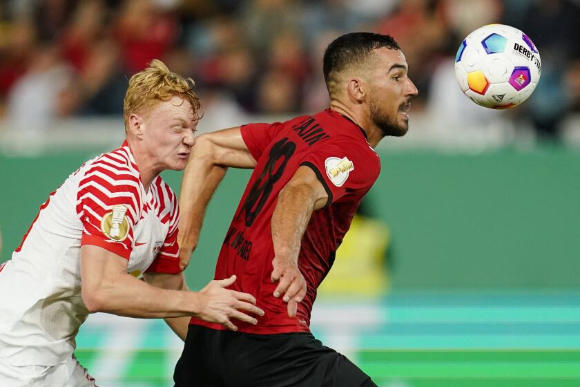Leipzig's Nicolas Seiwald, left, and Wiesbaden's Ivan Prtajin, right, challenge for the ball during the German soccer cup first round match between SV Wehen Wiesbaden and RB Leipzig in Wiesbaden, Germany, Wednesday, Sept. 27, 2023. (Uwe Anspach/dpa via AP)
