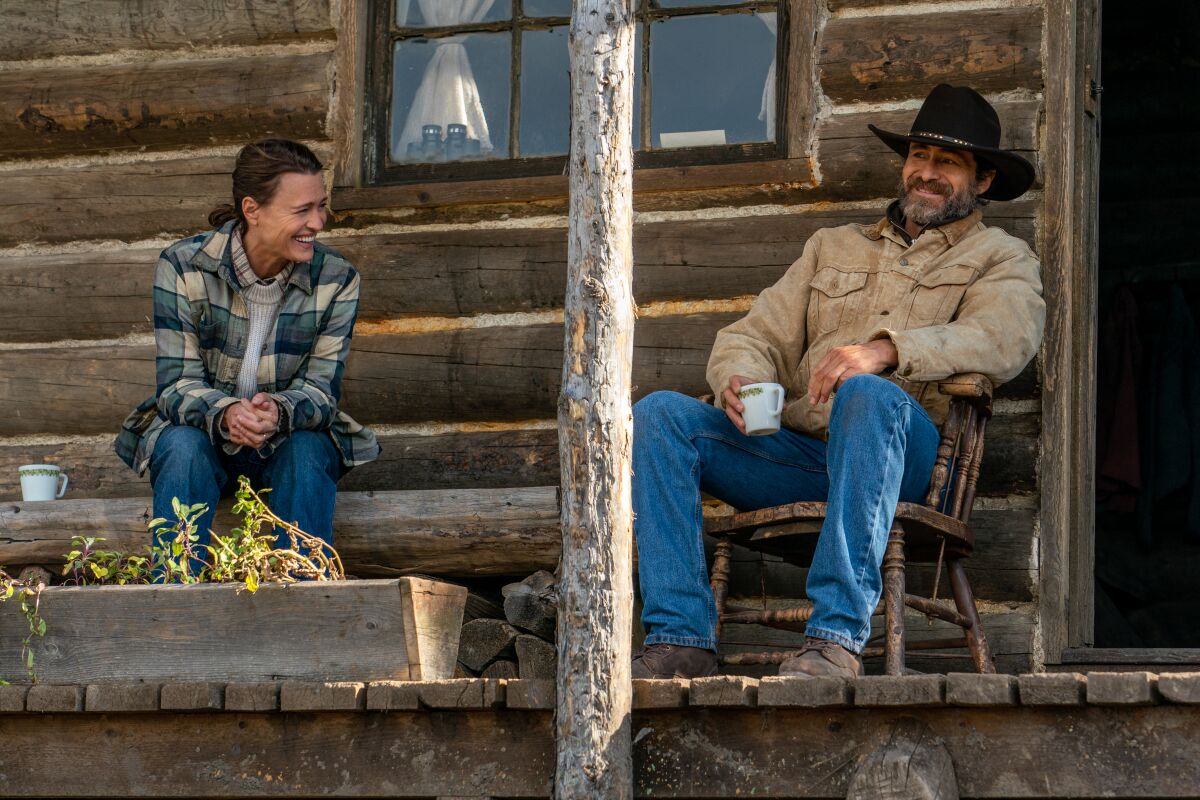 Robin Wright and Demián Bichir sit on a porch in the movie "Land."