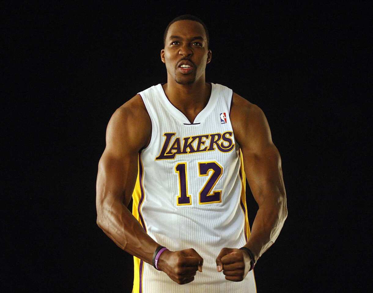 Newly acquired Lakers center Dwight Howard strikes a bodybuilder's pose during the team's media day Monday at its El Segundo training facility.