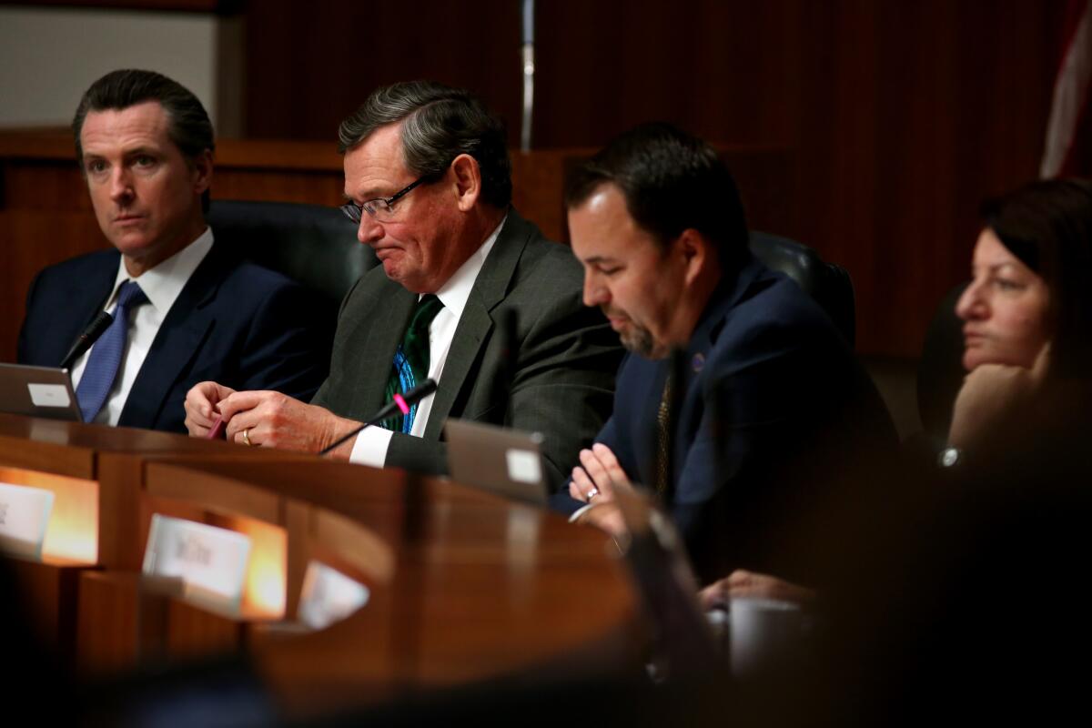 Lt. Gov. Gavin Newsom, left, Cal State Chancellor Timothy P. White, Chair Lou Monville and Assembly Speaker Toni Atkins in the Board of Trustees meeting where members voted on a revised compensation policy for Cal State executives.