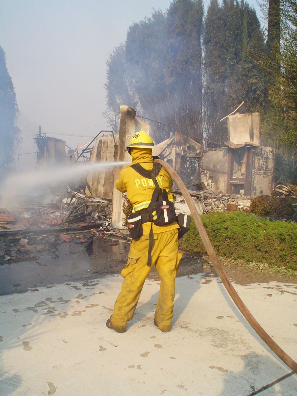 A Poway firefighter at a burning home during the Witch Creek fire in 2007.