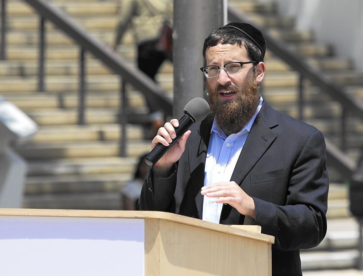 Rabbi Zevi Tenenbaum, co-director of the the Rohr Chabad at UC Irvine, speaks during a pro-Israel rally Thursday at UCI. “Our message here today is that we will be allowed to celebrate our Judaism,” Tenenbaum said. “We will be able to advocate for our cause, the pro-Israel cause.”