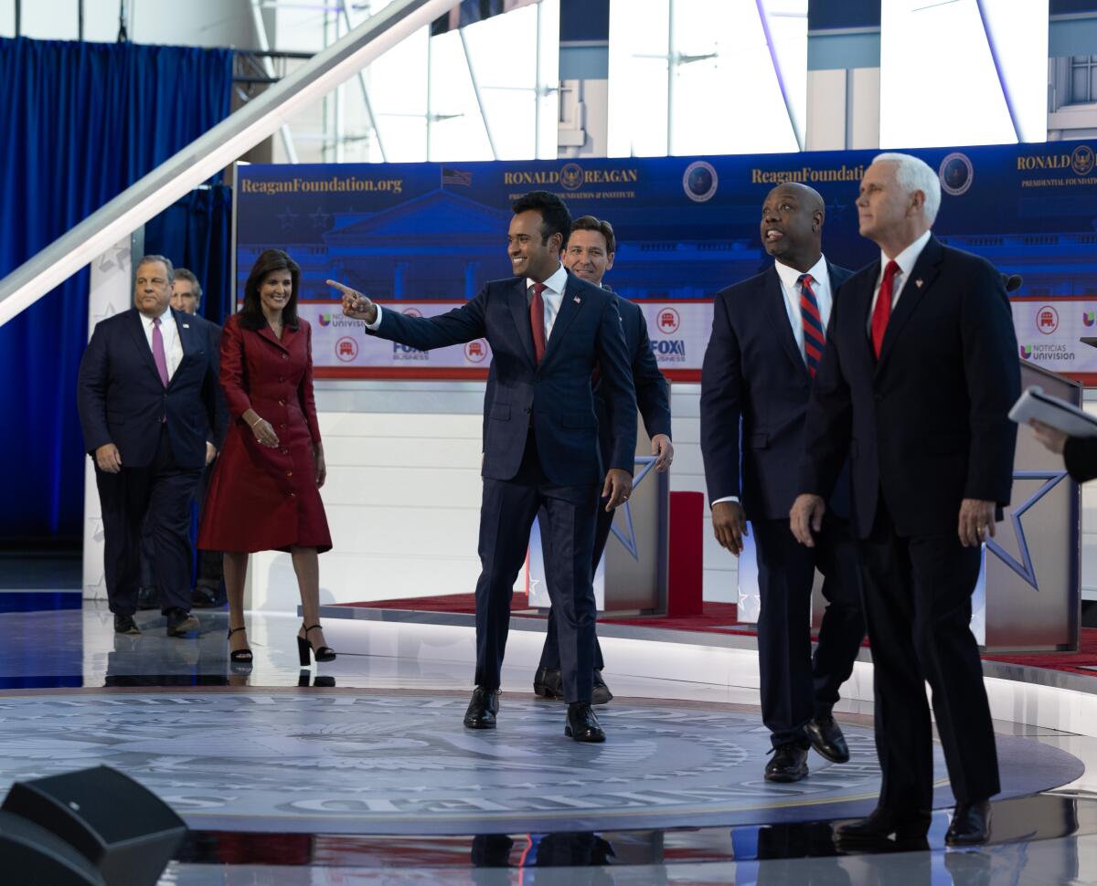 Republican presidential hopefuls are seen walking onto a stage decorated in red, white and blue.