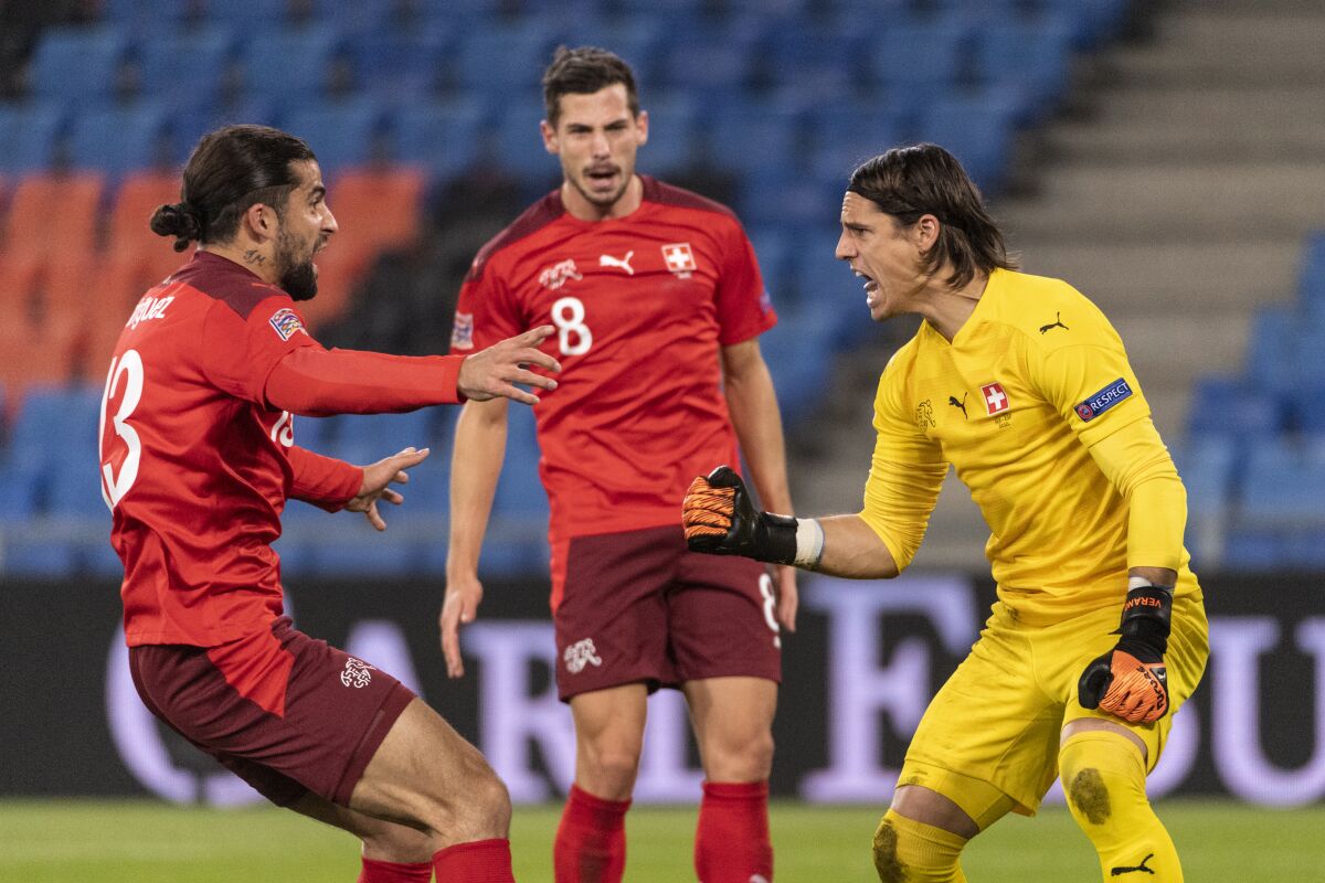 Switzerland's goalkeeper Yann Sommer, right, celebrates with Ricardo Rodriguez, left, and Remo Freuler, after stopping a penalty, during the UEFA Nations League soccer match between Switzerland and Spain at the St. Jakob-Park stadium in Basel, Switzerland, Saturday Nov. 14, 2020. (Alessandro della Valle/Keystone via AP)