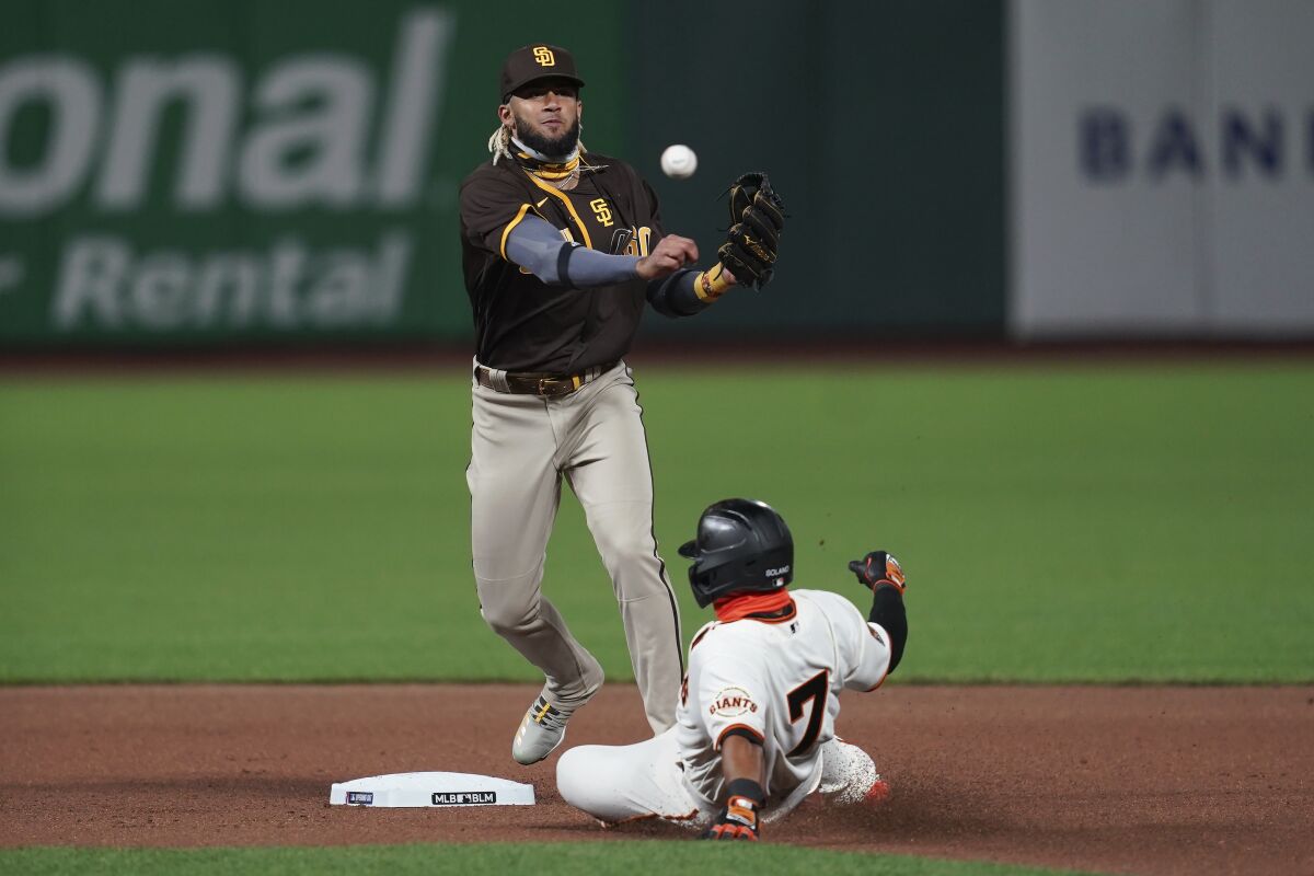 Padres shortstop Fernando Tatis Jr. throws to first base after forcing Giants' Donovan Solano out at second last month.