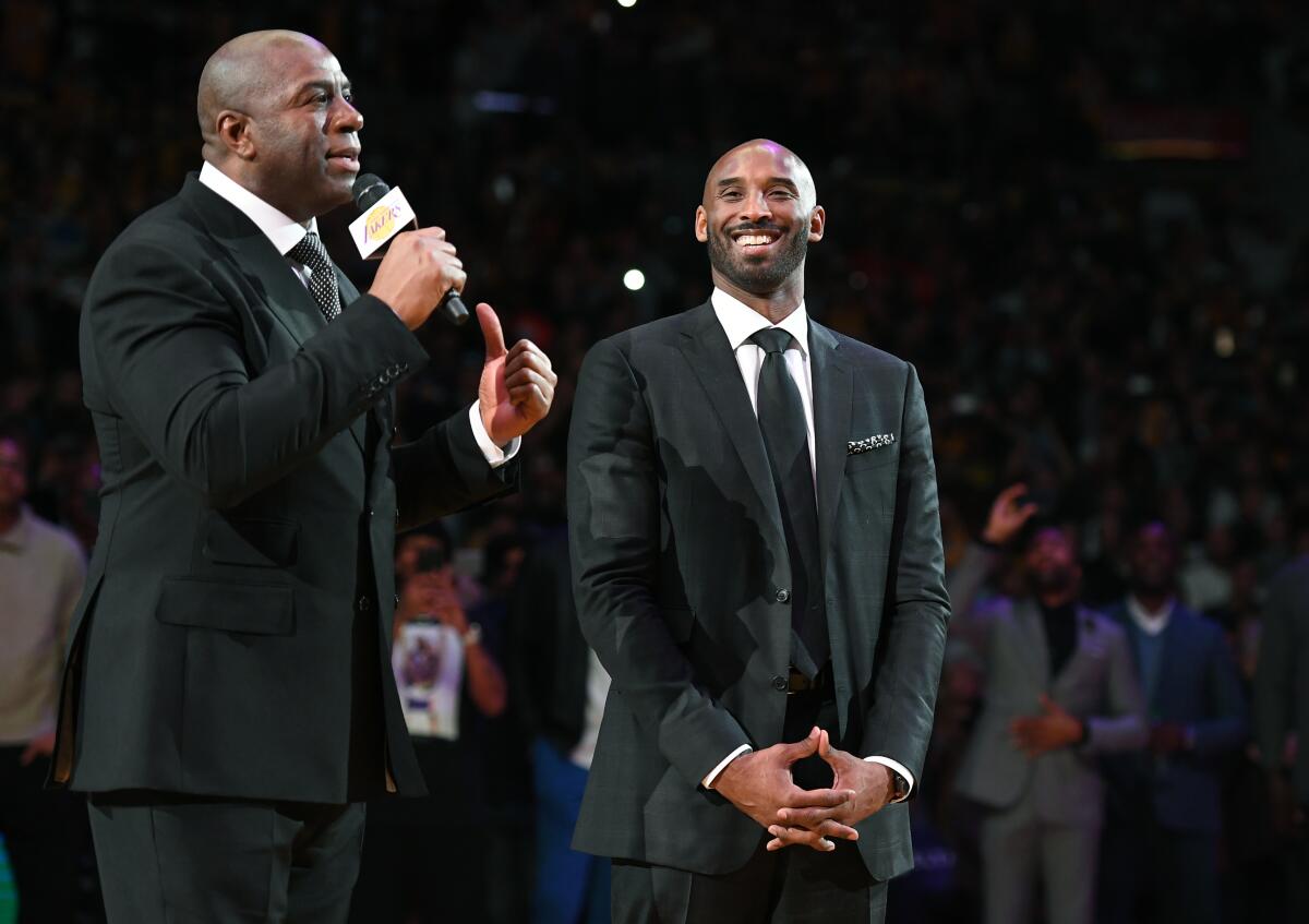 Former Lakers guard Magic Johnson, left, praises Kobe Bryant during Bryant's jersey retirement ceremony at Staples Center.
