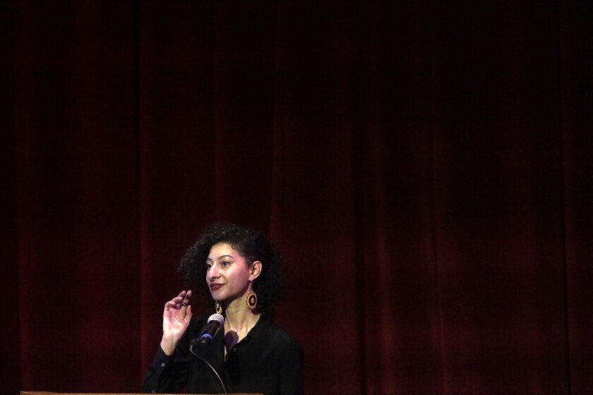 A woman speaks in an auditorium