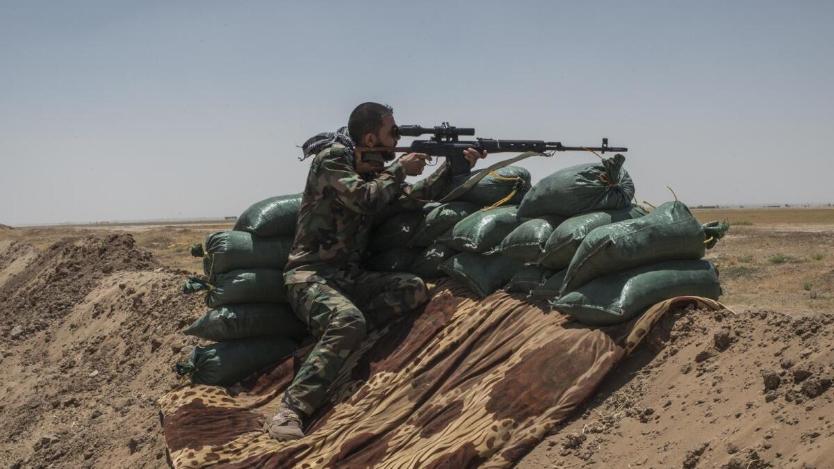 An Iraqi sniper takes aim this week in Nineveh, Iraq, near the Syria border.