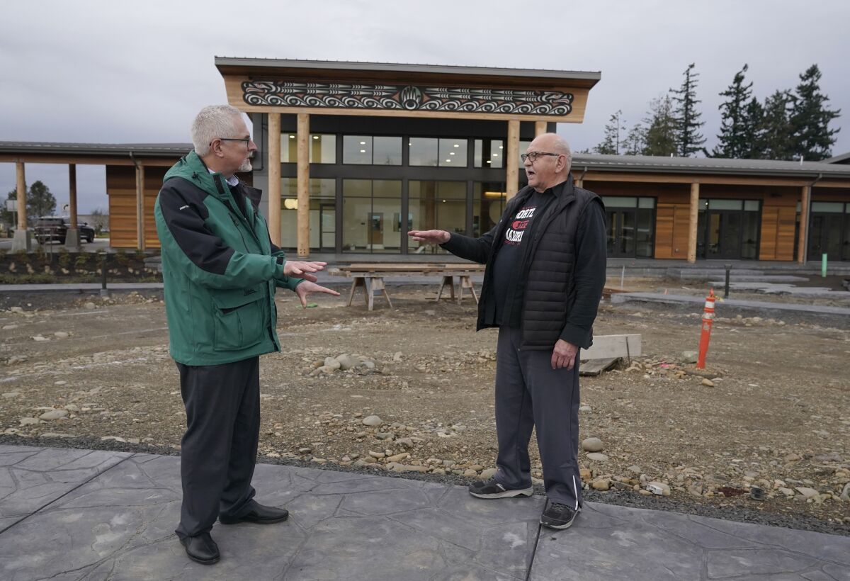 W. Ron Allen, right, chairman of the Jamestown S'Klallam Tribe, talks with Brent Simcosky, left, tribal health director, Wednesday, Feb. 2, 2022, in front of the Jamestown Healing Clinic, in Sequim, Wash. The tribe is building a full-service health center to treat both tribal members and other community residents for opioid addictions. Earlier in the week, Native American tribes across the U.S. settled a lawsuit against drug maker Johnson & Johnson and the largest three drug distribution companies in the U.S. for $590 million. The money won't be distributed quickly, but tribal leaders say it will play a part in healing their communities from an epidemic that has disproportionately killed Native Americans. (AP Photo/Ted S. Warren)