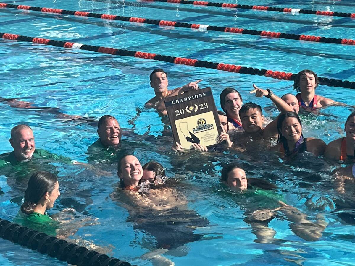 Members of the Costa Mesa High swim team celebrate after the Mustang boys won the CIF Southern Section Division 3 title.