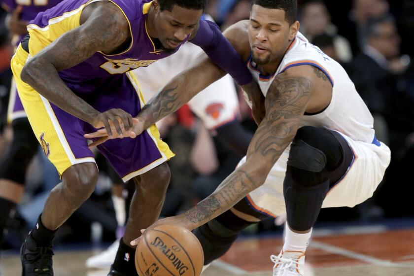Lakers guard Manny Harris, left, and Knicks forward Jeremy Tyler chase after a loose ball in the second half of a game on Jan. 26. Tyler signed a free-agent contract Tuesday with the Lakers.