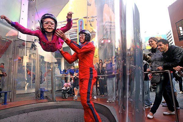 Jordan Hill, 5, left, flies with the help of indoor skydiving instructor Jonathan Townsager at IFly Hollywood in Universal City. Jordan's grandparents paid for the flight with discounted voucher they bought on the website Groupon.