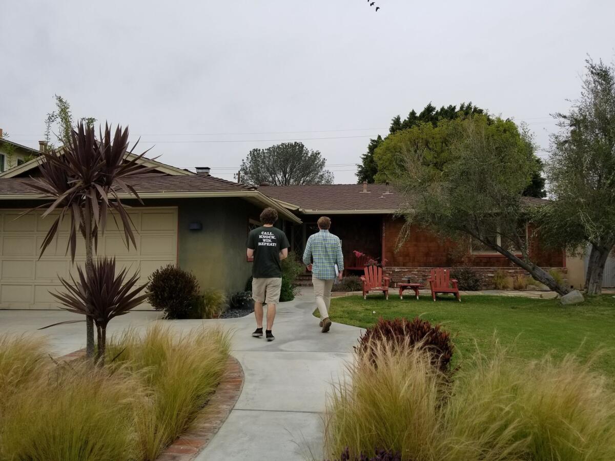 Joseph Joslin, left, and Evan Albertson canvass in Tustin on behalf of the Congressional Leadership Fund for Rep. Mimi Walters.