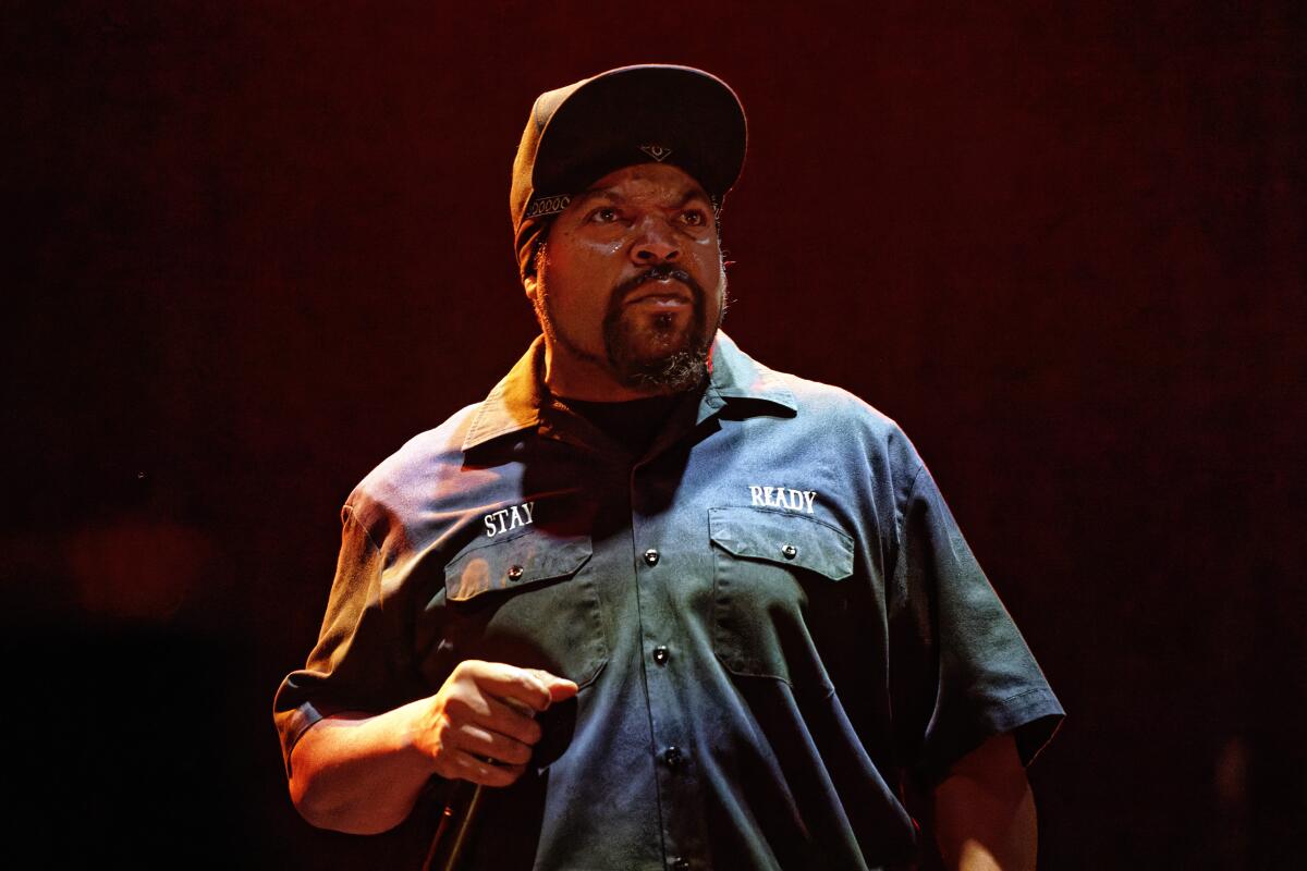 Ice Cube holds a microphone while performing.
