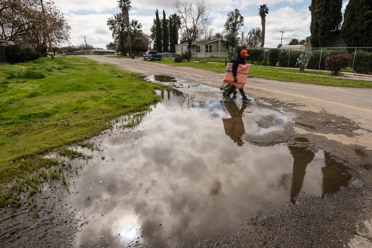 Lee Harris walks down a street in Fairmead, Calif., a tight-knit community that worked with officials to reduce the effect of high-speed rail. It now faces the most immediate uncertainties after state plans for the project have been curtailed.