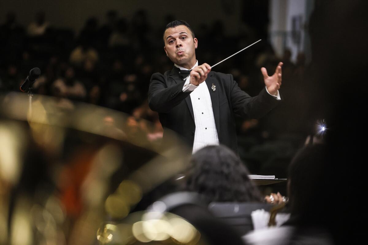 The band director at Inglewood High School, Joseph Jauregui, conducts during a performance.