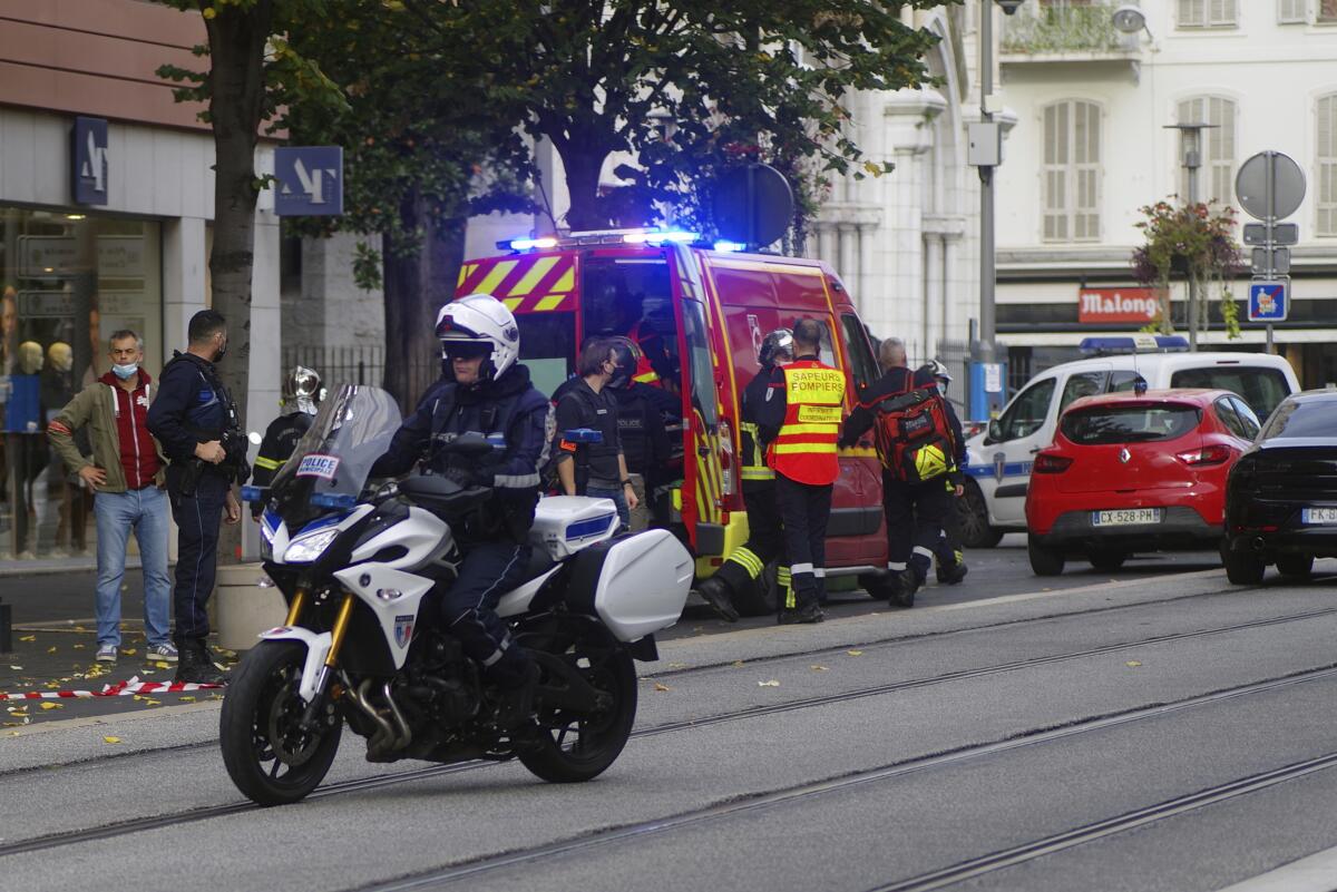 A police officer on a motorcycle as other emergency workers arrive on scene in Nice, France
