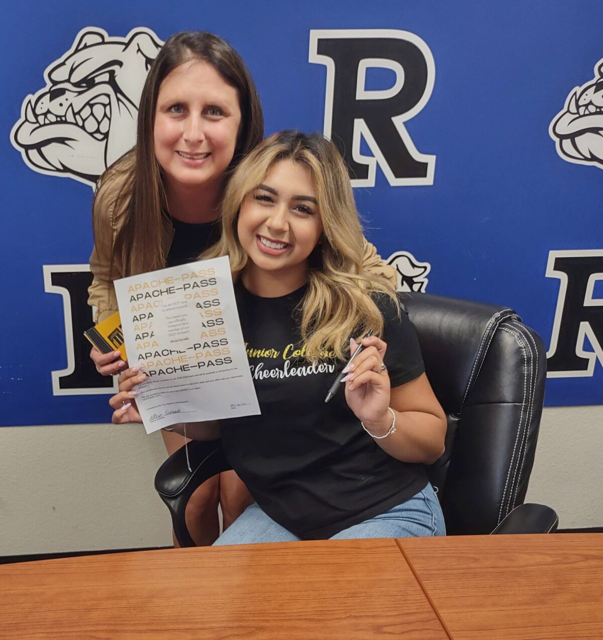 Alexis “Lexi” Estrada signs a pledge to cheer for the TJC Apaches Cheer Team with support from her mom, Christina Ocampo.
