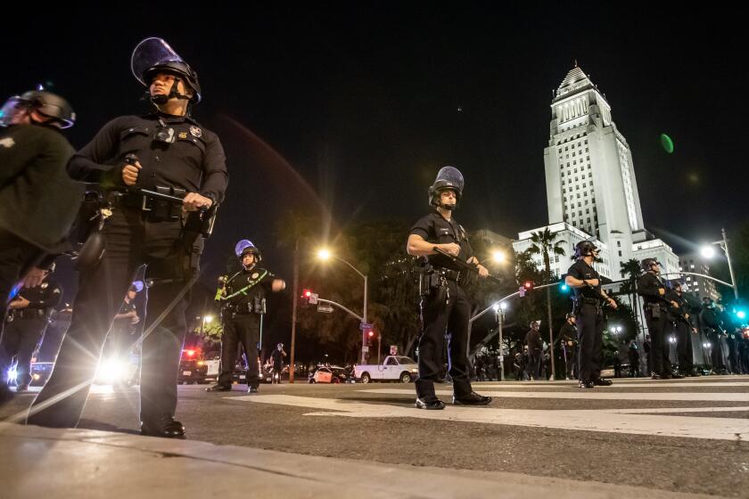 LOS ANGELES, CA - JANUARY 27, 2023: Los Angeles Police officers wearing riot gear near City Hall after crowds became unruly after a vigil for Tyre Nichols near LAPD on January 27, 2023 in Los Angeles, California. (Gina Ferazzi / Los Angeles Times)