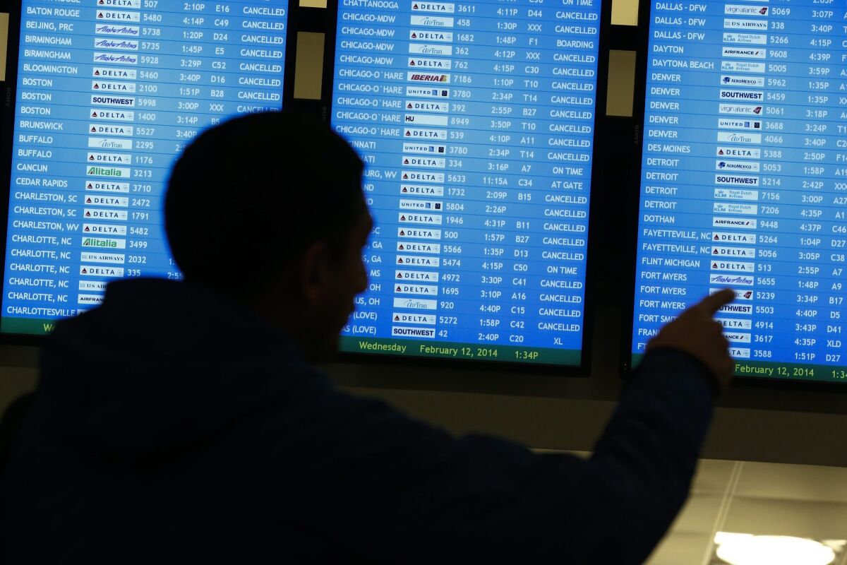 Canceled flights are seen on a video display at Hartsfield-Jackson Atlanta International Airport during a severe winter storm in February 2014. A new study suggests that airlines have been padding the allotted time for flights. Airlines say they set aside as much time as needed to deal with weather problems and tarmac congestion.
