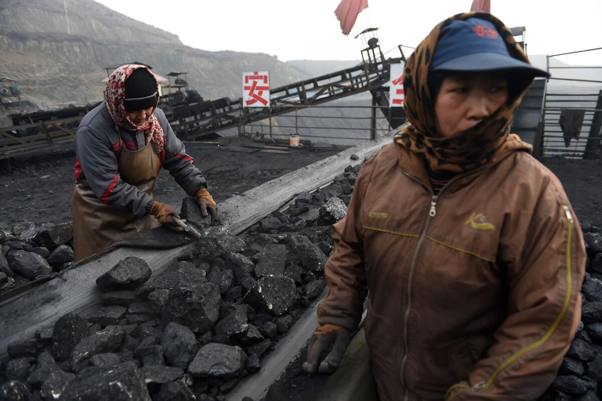 Workers sort coal on a conveyer belt near a mine in Datong, in China's northern Shanxi province.