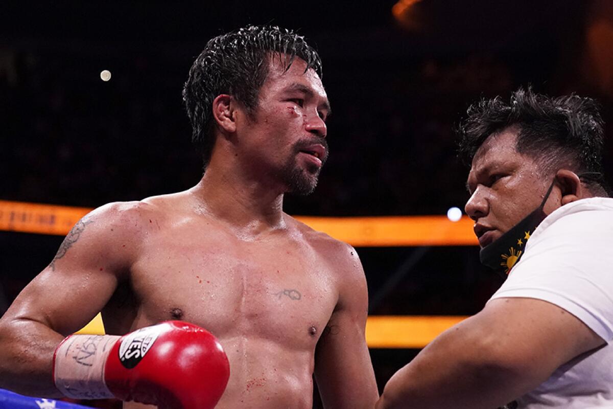 Manny Pacquiao stands next to his trainer in the aftermath of losing his fight against Yordenis Ugas on Saturday.