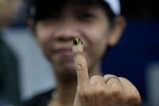 Una mujer muestra un dedo manchado de tinta que indica que ya votó en las elecciones generales, en Yakarta, Indonesia, el 14 de febrero de 2024. (AP Foto/Dita Alangkara)