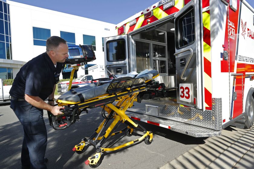 SAN DIEGO, CA - OCTOBER 13: EMT Patrick Hillman loads a gurney into a new Falck ambulance in Kearney Mesa on Wednesday, Oct. 13, 2021. Falck will take over ambulance service in San Diego on November 27. (K.C. Alfred / The San Diego Union-Tribune)