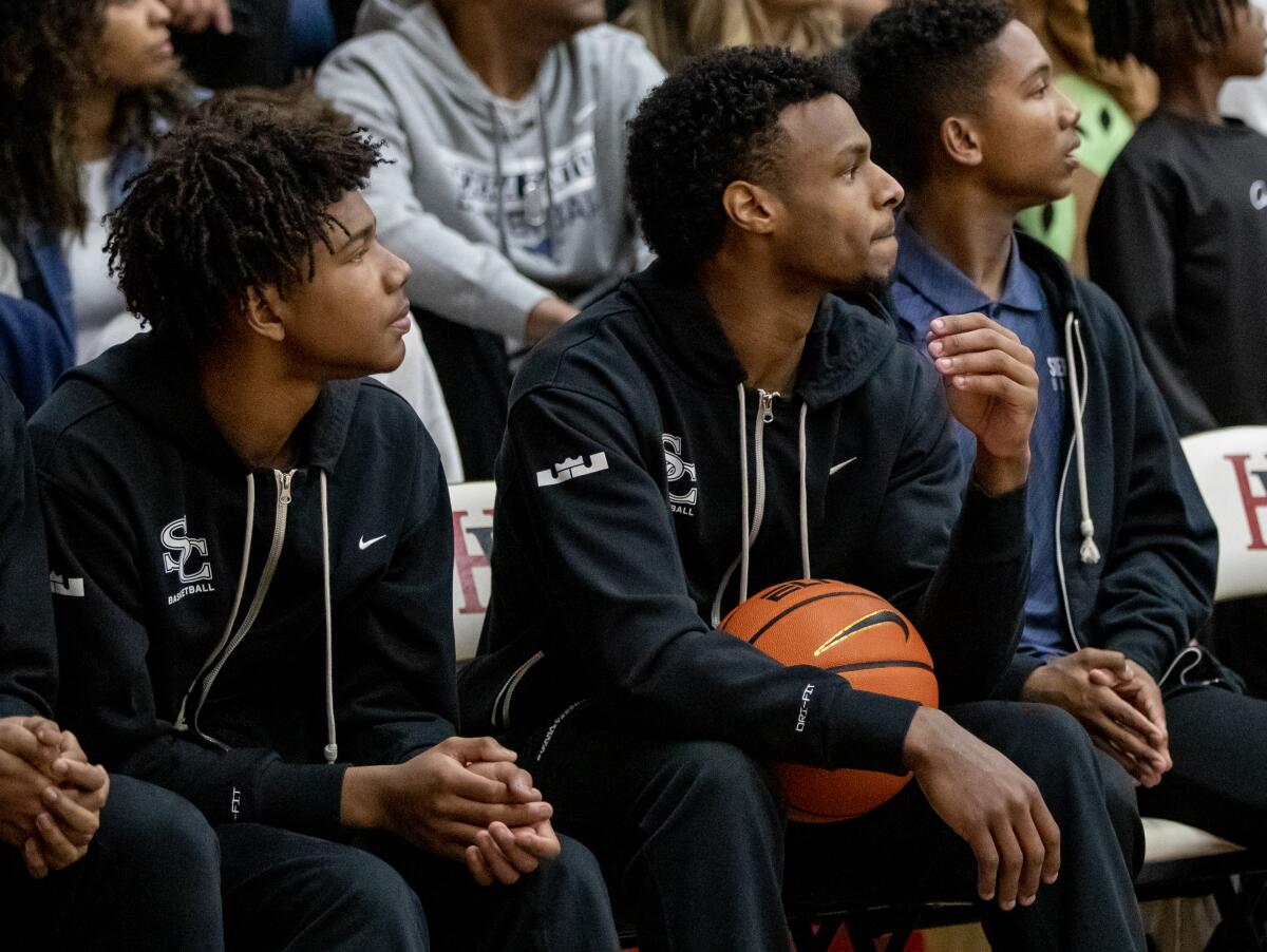 Sierra Canyon's Bronny James, middle, watches during the Trailblazers' loss to Harvard-Westlake on Jan. 20, 2023.