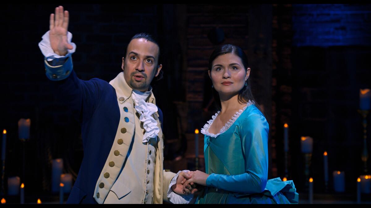 Lin-Manuel Miranda and Phillipa Soo, in costume in "Hamilton," look out into the audience.